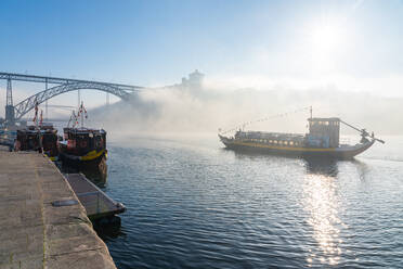 Boot auf dem Fluss Douro im frühen Morgennebel mit der Dom-Luis-I-Brücke im Hintergrund, Porto, Portugal, Europa - RHPLF16697