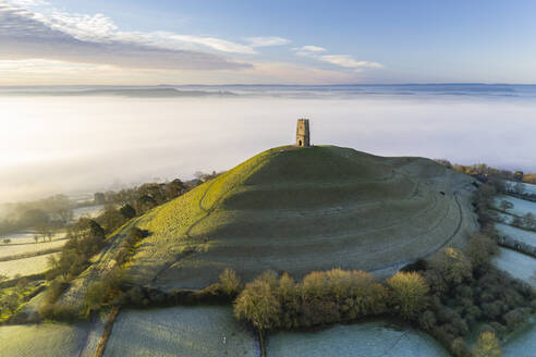 Blick per Drohne auf den St. Michael's Tower auf dem Glastonbury Tor in der Morgendämmerung im Winter, Somerset, England, Vereinigtes Königreich, Europa - RHPLF16754