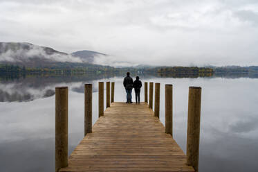 Ein Paar steht auf dem Ashness Pier Landing Jetty, Derwentwater, Keswick, Lake District National Park, UNESCO-Weltkulturerbe, Cumbria, England, Vereinigtes Königreich, Europa - RHPLF16873