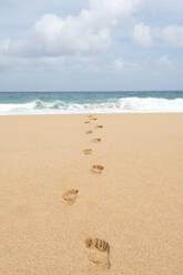 Footsteps on the beach leading into the ocean in the Hawaiian island of Kauai, Hawaii, United States of America, North America - RHPLF16889