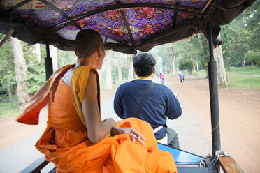 Buddhistischer Mönch fährt in einem Tuktuk im archäologischen Park von Angkor in Siem Reap, Kambodscha, Indochina, Südostasien, Asien - RHPLF16897