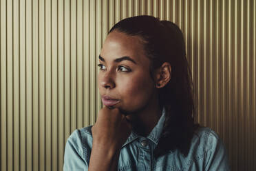 Close-up of thoughtful young woman looking away against wall - DSIF00071