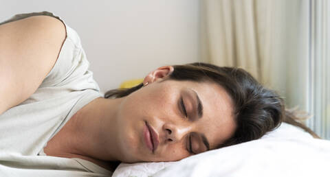 Woman sleeping in bedroom stock photo