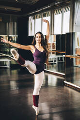 Expressive dancer in bodysuit on tiptoes dancing in class. - ADSF07187