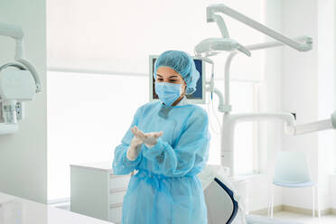 Krankenschwester mit Handschuhen in der Zahnarztpraxis - DLTSF00920