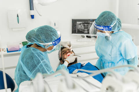 Eine Krankenschwester untersucht einen männlichen Patienten in einer Zahnklinik, lizenzfreies Stockfoto