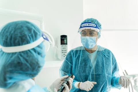 Ärztin im Gespräch mit Krankenschwester in der Zahnklinik, lizenzfreies Stockfoto