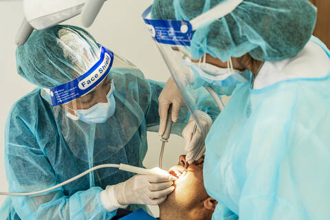 Doctor and female nurse examining patient in dentist's clinic stock photo