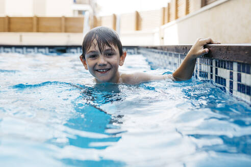 Lächelnder Junge, der sich im Sommer im Schwimmbad vergnügt - JRFF04677