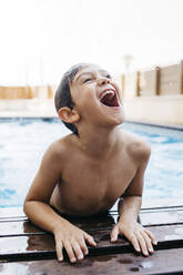 Fröhlicher Junge, der am Pool aufsteht - JRFF04684