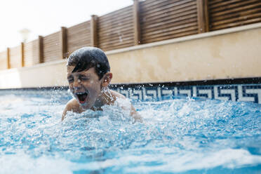 Boy enjoying in swimming pool during summer - JRFF04689