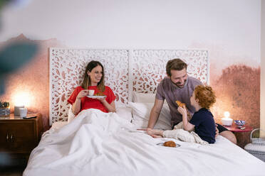 Glückliche Eltern mit Sohn beim Frühstück im Bett zu Hause - EIF00147
