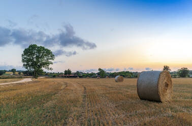 Ländliches Dorf mit Strohballen bei Sonnenuntergang an der Mittelmeerküste - CAVF87669