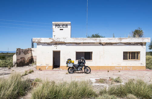 Vor einer verlassenen Polizeistation geparktes Tourenmotorrad - CAVF87740