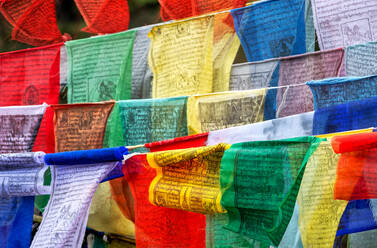 Buddhistische Gebetsfahnen mit den Wünschen der Gläubigen wiegen sich im Wind, Bhutan, Asien - RHPLF17024