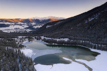 Sunrise over the village of Dobbiaco and frozen lake, Val Pusteria, Dolomites, Bolzano province, South Tyrol, Italy, Europe - RHPLF17055