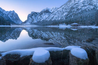 Winter dusk over Lake Dobbiaco surrounded by snow, Dobbiaco, Val Pusteria, Dolomites, Bolzano province, South Tyrol, Italy, Europe - RHPLF17057