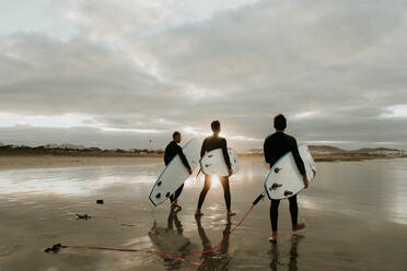 Menschen mit Surfbrett gehen in der Nähe von Meer - ADSF07289