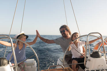 Glücklicher Vater mit Kindern schwimmt auf teuren Boot auf dem Meer und blauen Himmel in sonnigen Tag - ADSF07315