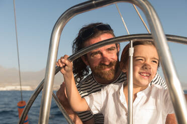 Glücklicher Vater mit Kindern schwimmt auf teuren Boot auf dem Meer und blauen Himmel in sonnigen Tag - ADSF07316