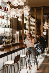 Stylish woman drinking wine in bar - ADSF07390