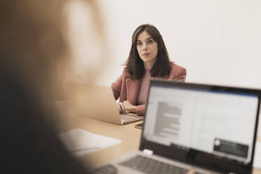 Konzentrierte junge Frauen, die auf Laptops surfen und am Tisch im Büro sitzen - ADSF07402