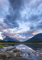 Malerische Ansicht der Wasseroberfläche und des Ufers mit Steinhügeln und bewölktem Himmel in Banff, Kanada - ADSF07411