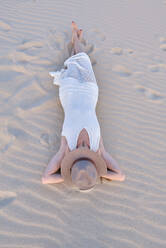 Von oben Frau in weißem Kleid und Hut am Sandstrand in Tarifa, Spanien - ADSF07449