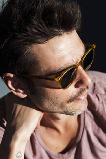 Nahaufnahme eines coolen erwachsenen Mannes mit Sonnenbrille an einem sonnigen Tag - JMPF00259