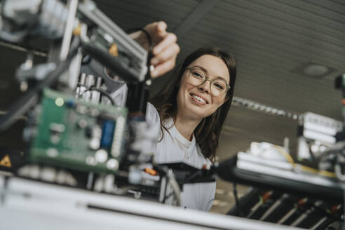 Nahaufnahme einer Wissenschaftlerin bei der Installation von Maschinen im Labor - MFF05906