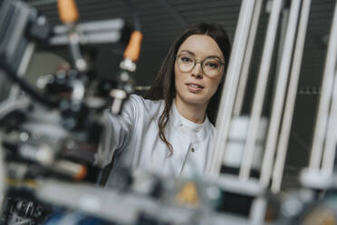 Close-up of female scientist examining equipment in laboratory at factory - MFF05908