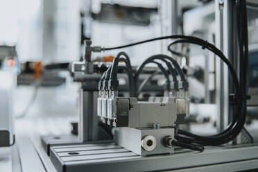 Close-up of machinery with cables on table in laboratory at factory - MFF05951