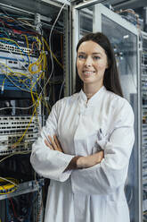 Female IT professional with arms crossed standing in server room - MFF05959