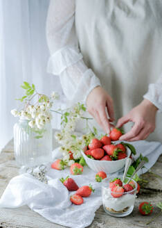 Gesichtsloser Koch mit frischen, saftigen, leckeren Erdbeeren bei der Zubereitung eines cremigen, süßen Desserts - ADSF07648