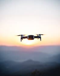 Schwarz und weiß fliegende Drohne hoch im Sonnenuntergang Himmel - ADSF07747