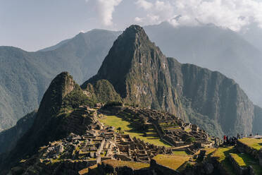 Machu Picchu, Peru: Erstaunliche touristische Landschaft des alten Labyrinths auf dem steinernen Gipfel des Berges unter bewölktem Himmel - ADSF07813