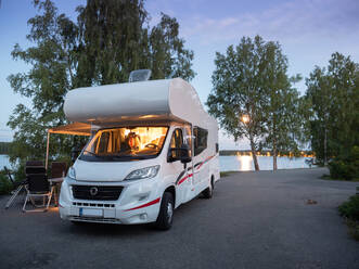 Weißer stilvoller Wohnmobilstellplatz für ein gemütliches Picknick am See im Sommerabend - ADSF08060