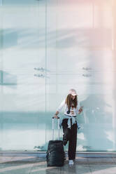 Calm woman using phone in airport - ADSF08098