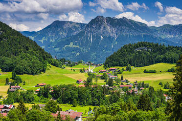 Deutschland, Bayern, Tiefenbach, Ländliches Dorf in den Allgäuer Alpen mit Entschenkopf und Rubihorn im Hintergrund - WGF01346