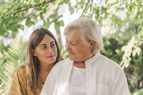 Close-up of smiling mother and daughter looking at each other in yard - ERRF04185