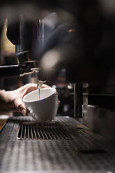 Crop Hände des Mannes, die Kaffee durch automatische professionelle Ausrüstung in Cafe - ADSF08378
