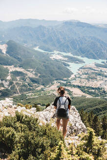 Rückenansicht eines anonymen weiblichen Touristen in Freizeitkleidung, der die malerische Landschaft an einem sonnigen Sommertag genießt - ADSF08448