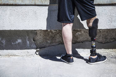 Unrecognizable young man amputated with his leg prosthesis on an access ramp - ADSF08484