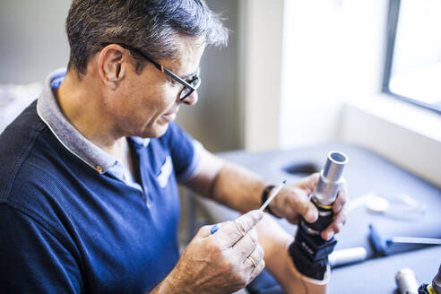 Prothetikingenieur, der die Prothese eines Patienten überprüft und das Material in seiner Werkstatt verbessert - ADSF08489