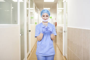Chirurgin ruht sich aus, während sie Nachrichten auf ihrem Smartphone abruft - ADSF08503