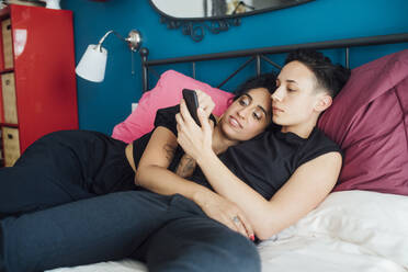 Lesbisches Paar benutzt Telefon im Schlafzimmer - MEUF01752
