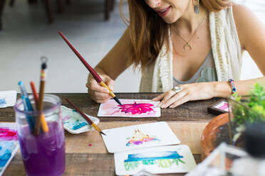 Lateinamerikanische Künstlerin malt mit Aquarellfarben in ihrem Atelier - ADSF08694