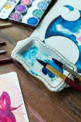 Lateinamerikanische Künstlerin malt mit Aquarellfarben in ihrem Atelier - ADSF08696