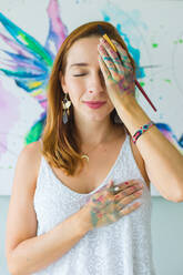 Lateinamerikanische Künstlerin malt mit Aquarellfarben in ihrem Atelier - ADSF08704