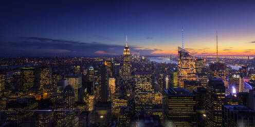 Weitwinkel-Drohne Ansicht der beleuchteten Wolkenkratzer in der Innenstadt von modernen Stadt gegen bewölkten Himmel Sonnenuntergang befindet - ADSF08722